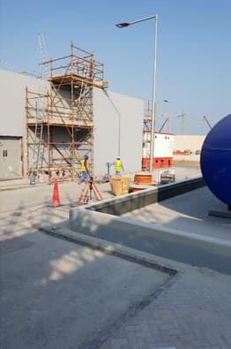 Scaffold tower beside tank